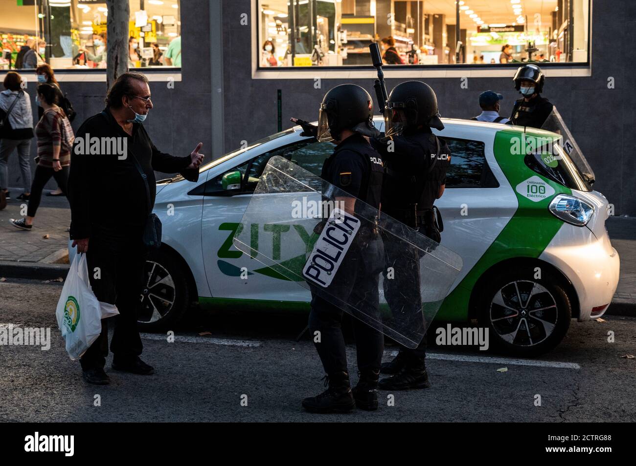 Madrid, Spagna. 24 Settembre 2020. Un uomo che cerca di parlare con la polizia antisommossa durante una protesta nel quartiere di Vallecas contro le nuove misure restrittive per fermare la diffusione del coronavirus che limitano la mobilità in 37 aree più colpite dal COVID-19. Credit: Marcos del Mazo/Alamy Live News Foto Stock