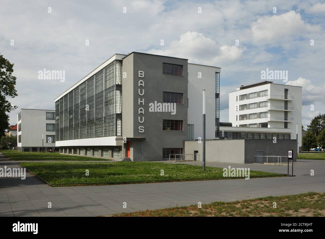 Edificio Bauhaus progettato dall'architetto modernista tedesco Walter Gropius (1925-1926) a Dessau in Sassonia-Anhalt, Germania. La tipografia disegnata dal graphic designer austriaco Herbert Bayer è posta sul blocco d'officina. Il blocco dormitorio è visto sullo sfondo a destra. Foto Stock
