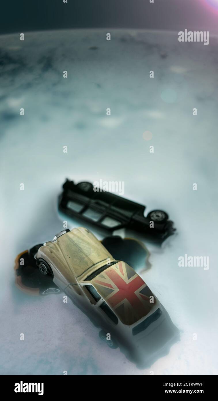 Una visione apocalittica della scomparsa di un territorio terrestre a seguito di un cataclisma naturale o provocato, di automobili britanniche rovesciate e di un simbolo britannico. Foto Stock