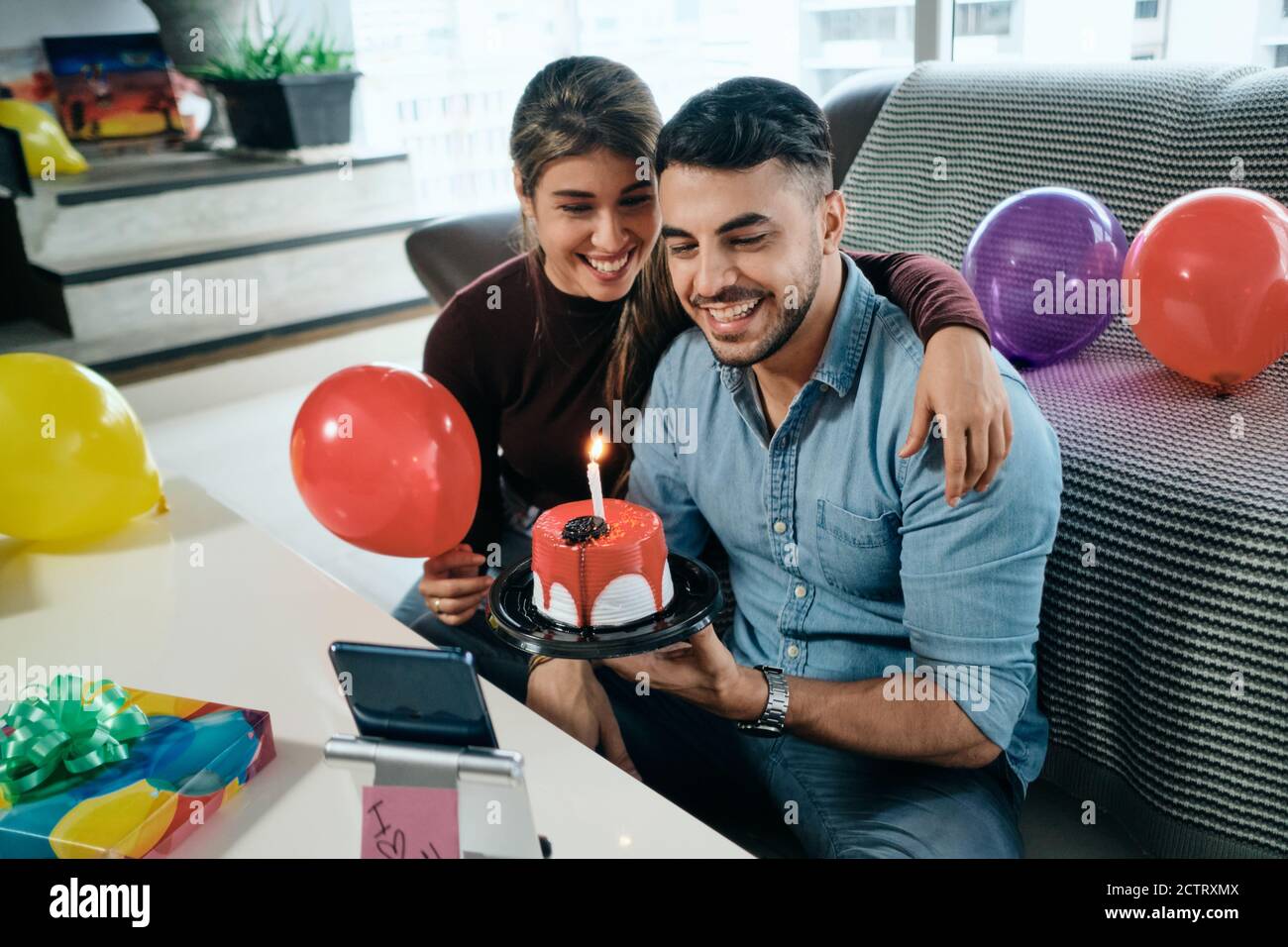 Felice gente che celebra la festa di compleanno via Zoom su smartphone Foto Stock