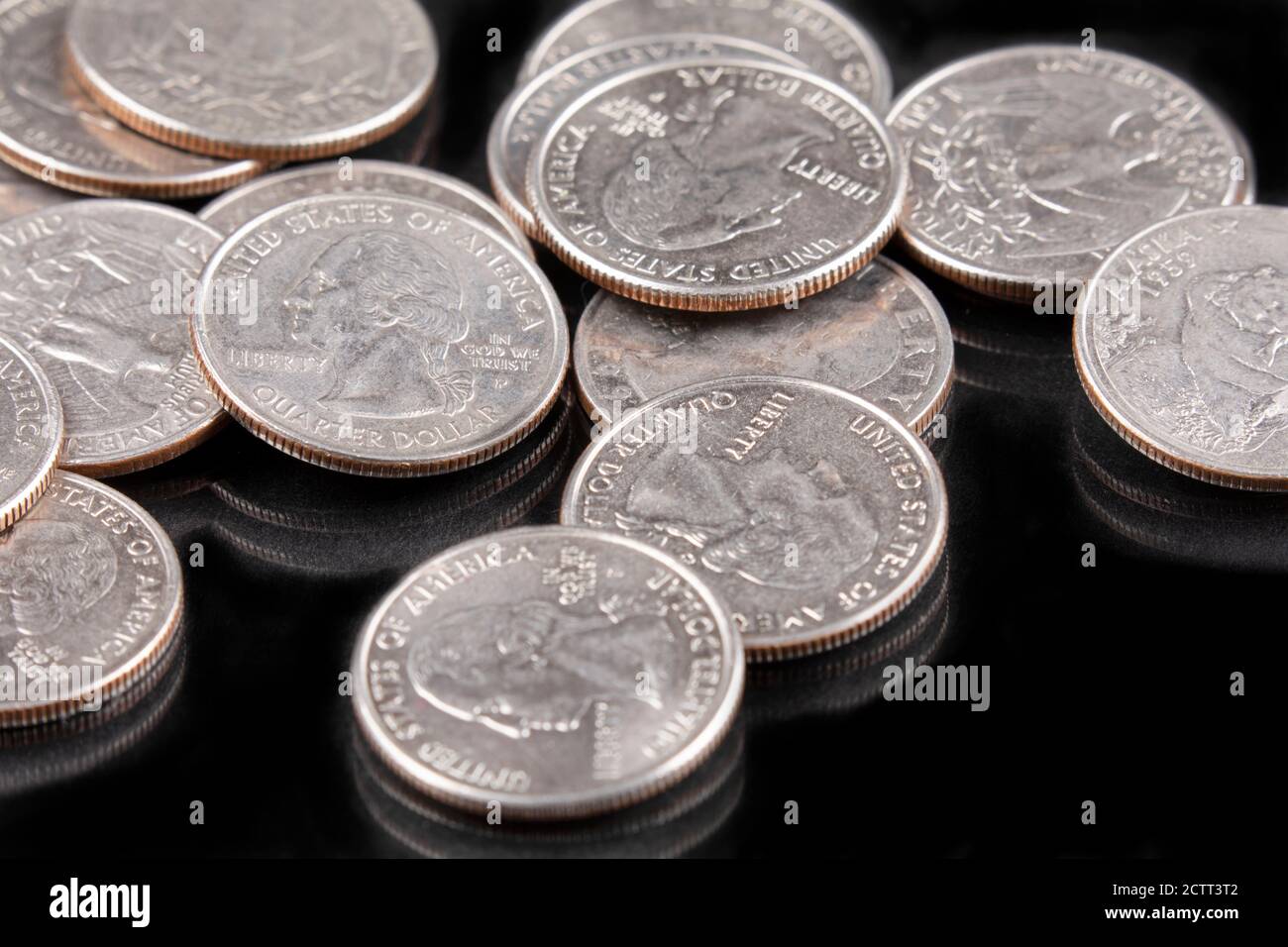 Uno sfondo di monete di United States Quarters su sfondo nero Foto Stock
