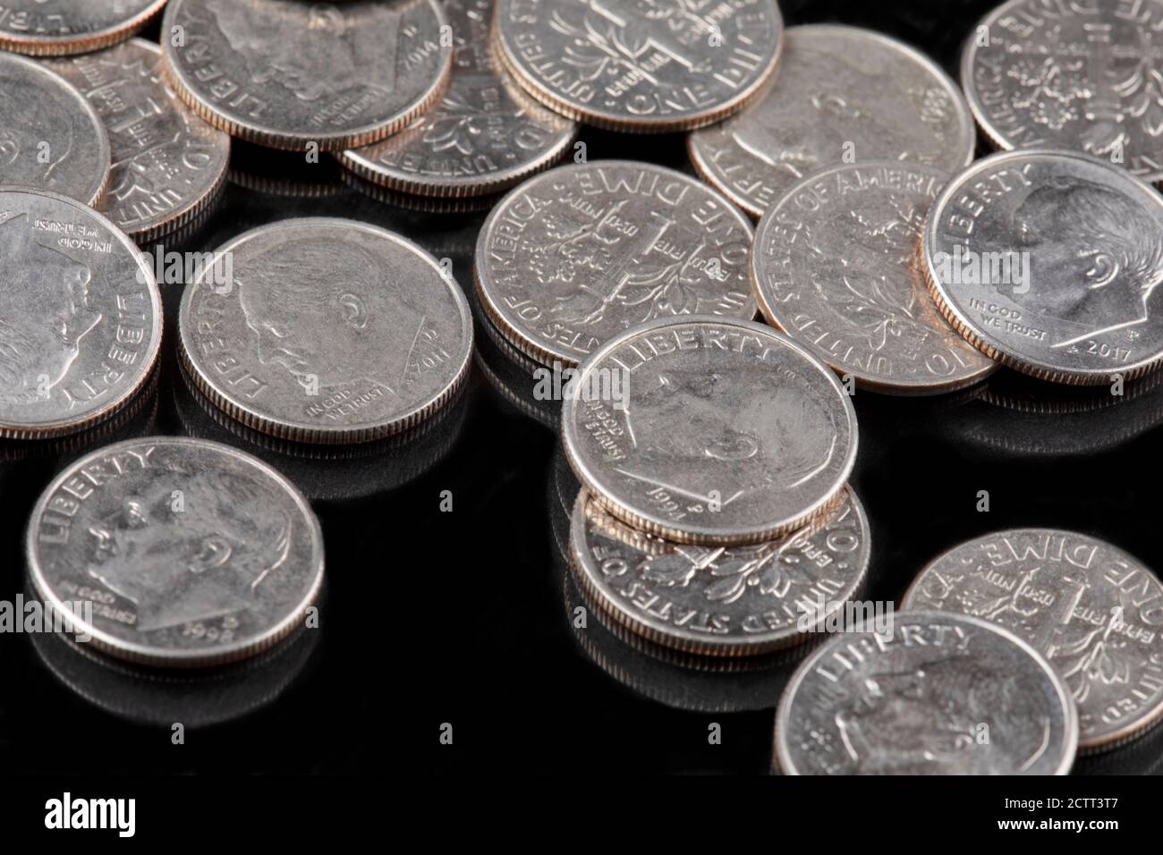 Uno sfondo di monete dime degli Stati Uniti su sfondo nero Foto Stock