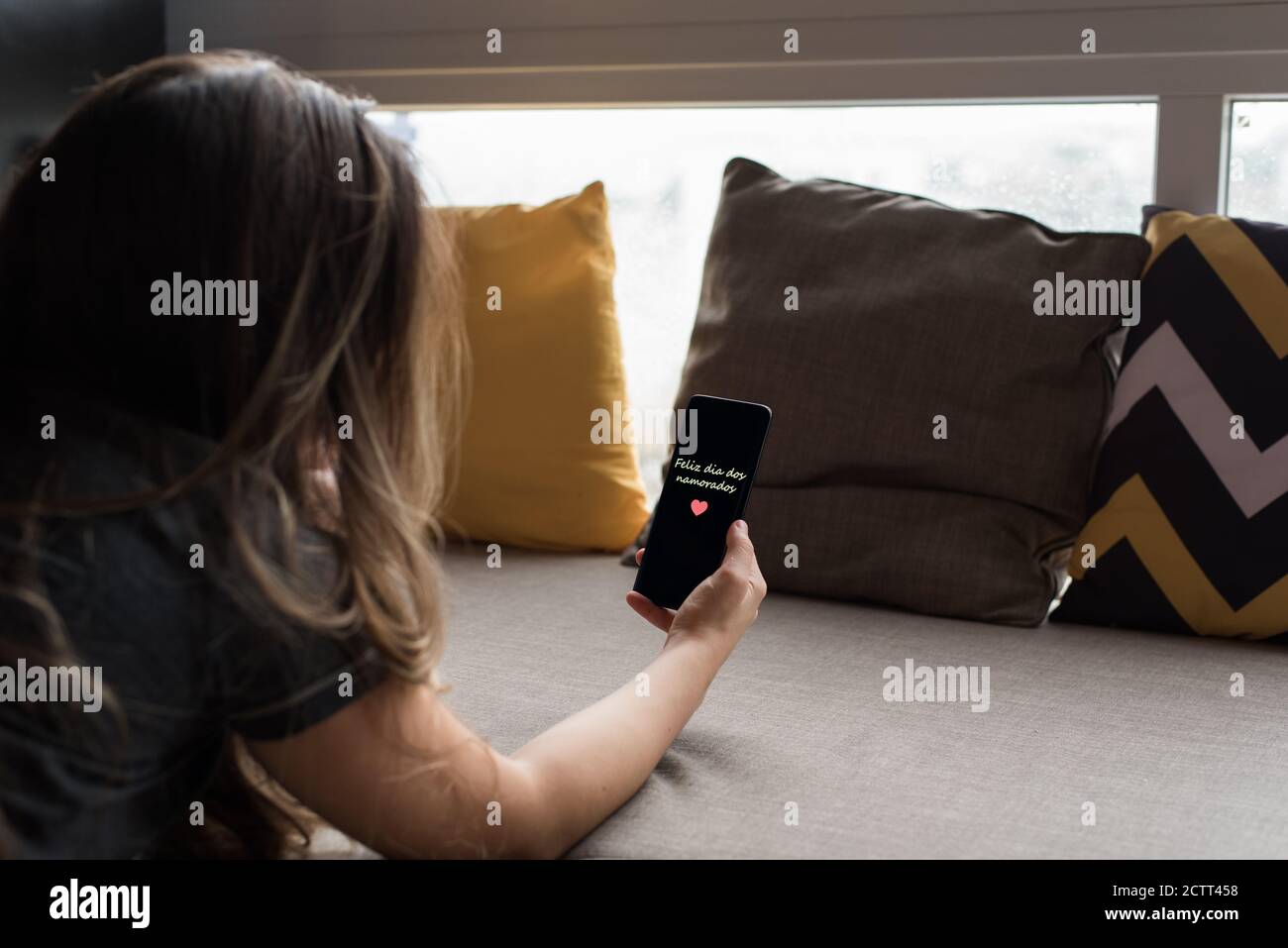 Donna brasiliana appeso un cellulare scritto 'Feliz dia dos Namorados' Foto Stock