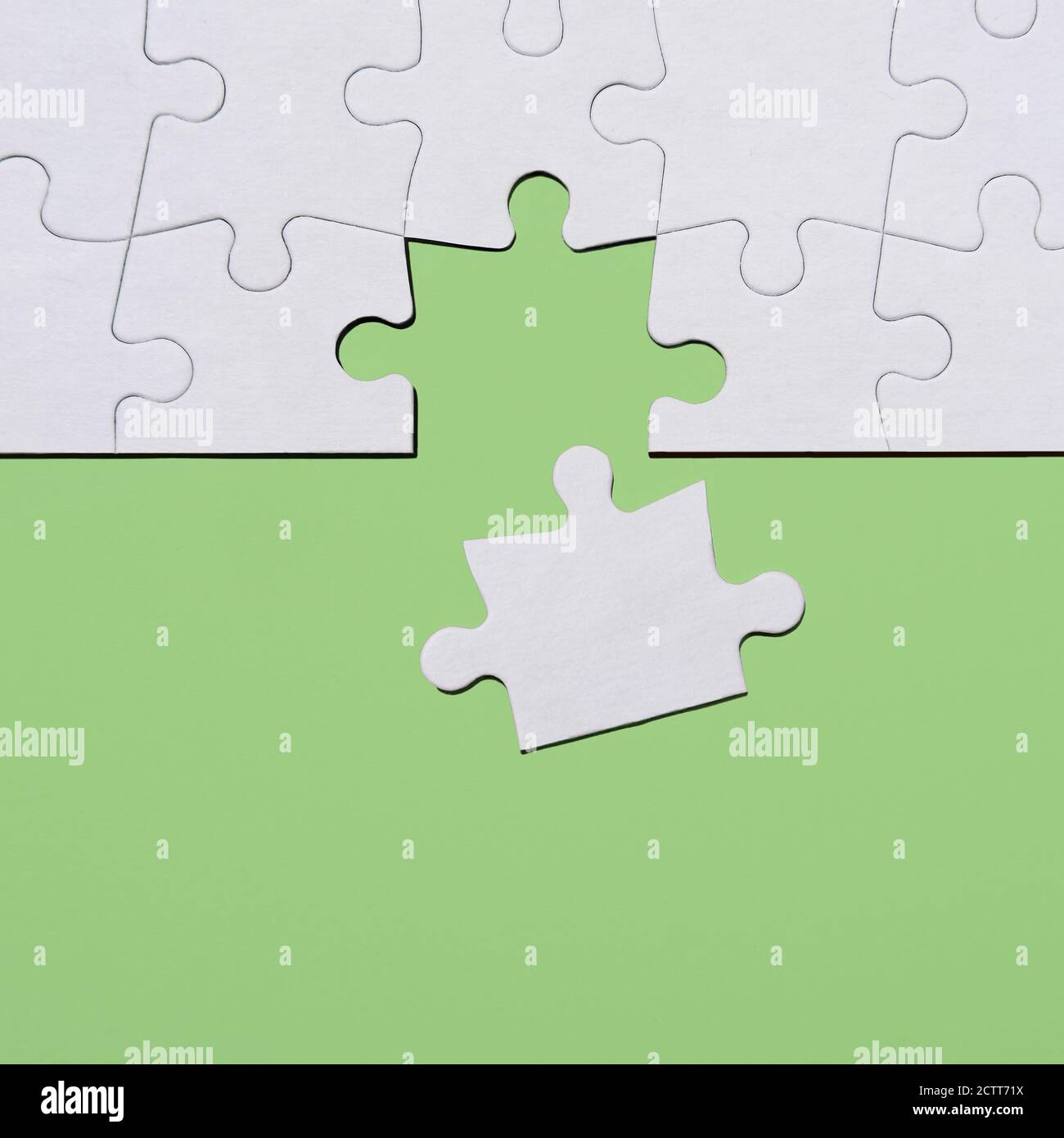 Ultimo pezzo di puzzle in puzzle su sfondo verde Foto Stock