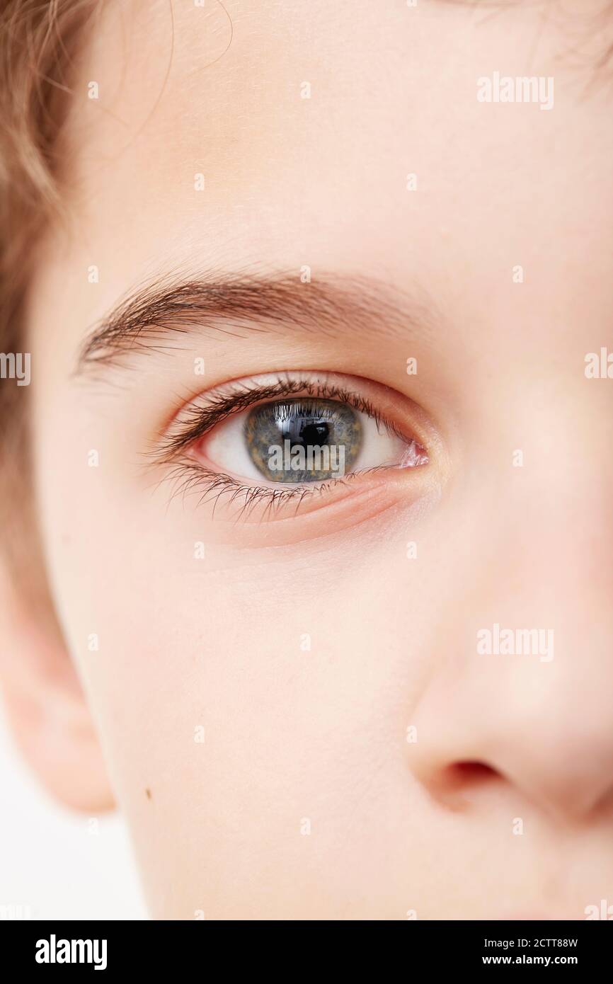 Primo piano del volto del ragazzo (8-9) con gli occhi blu Foto Stock