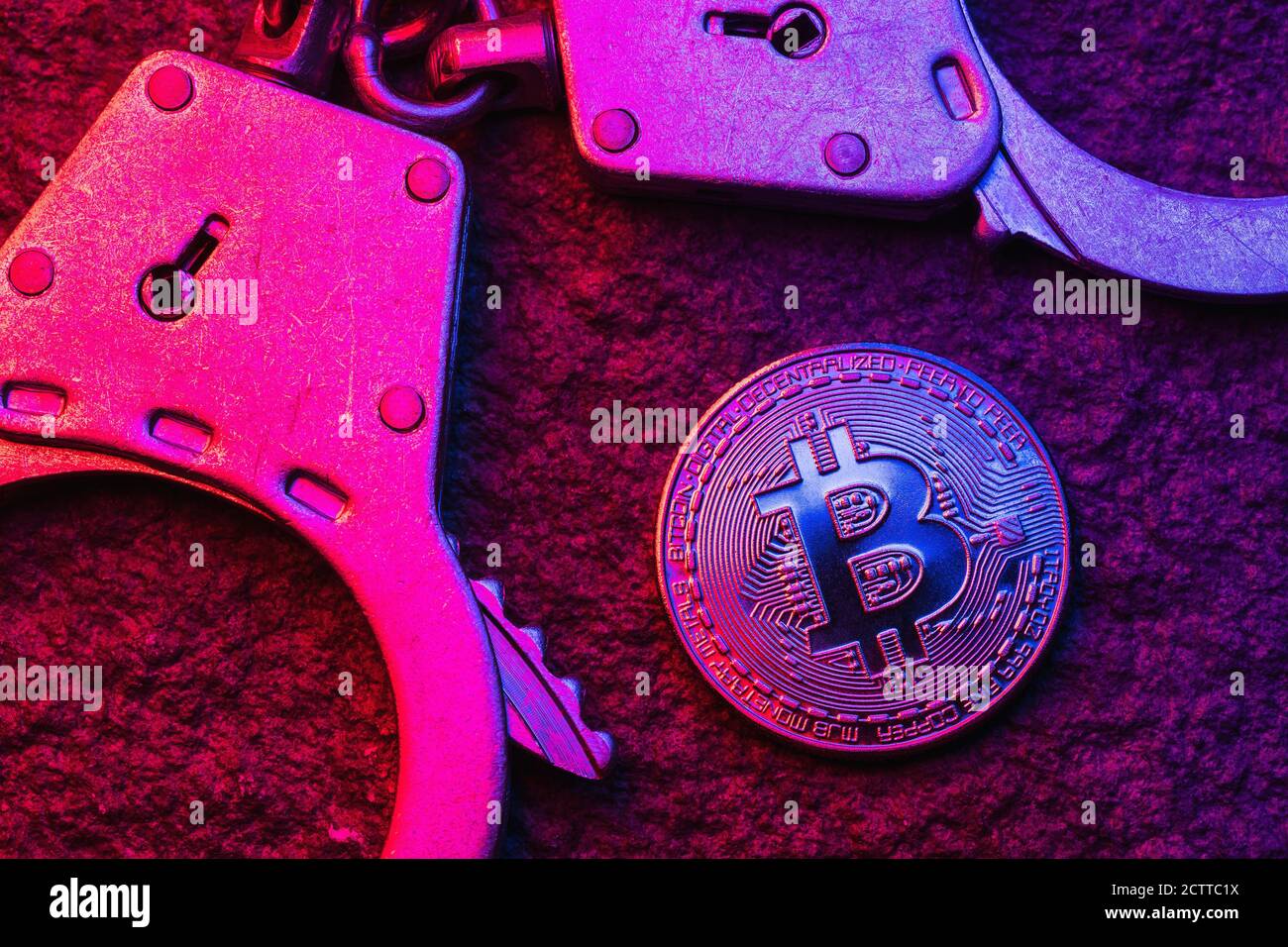 Manette e bitrone sul tavolo, vista dall'alto. Concetto sul tema delle attività fraudolente con la valuta digitale Foto Stock