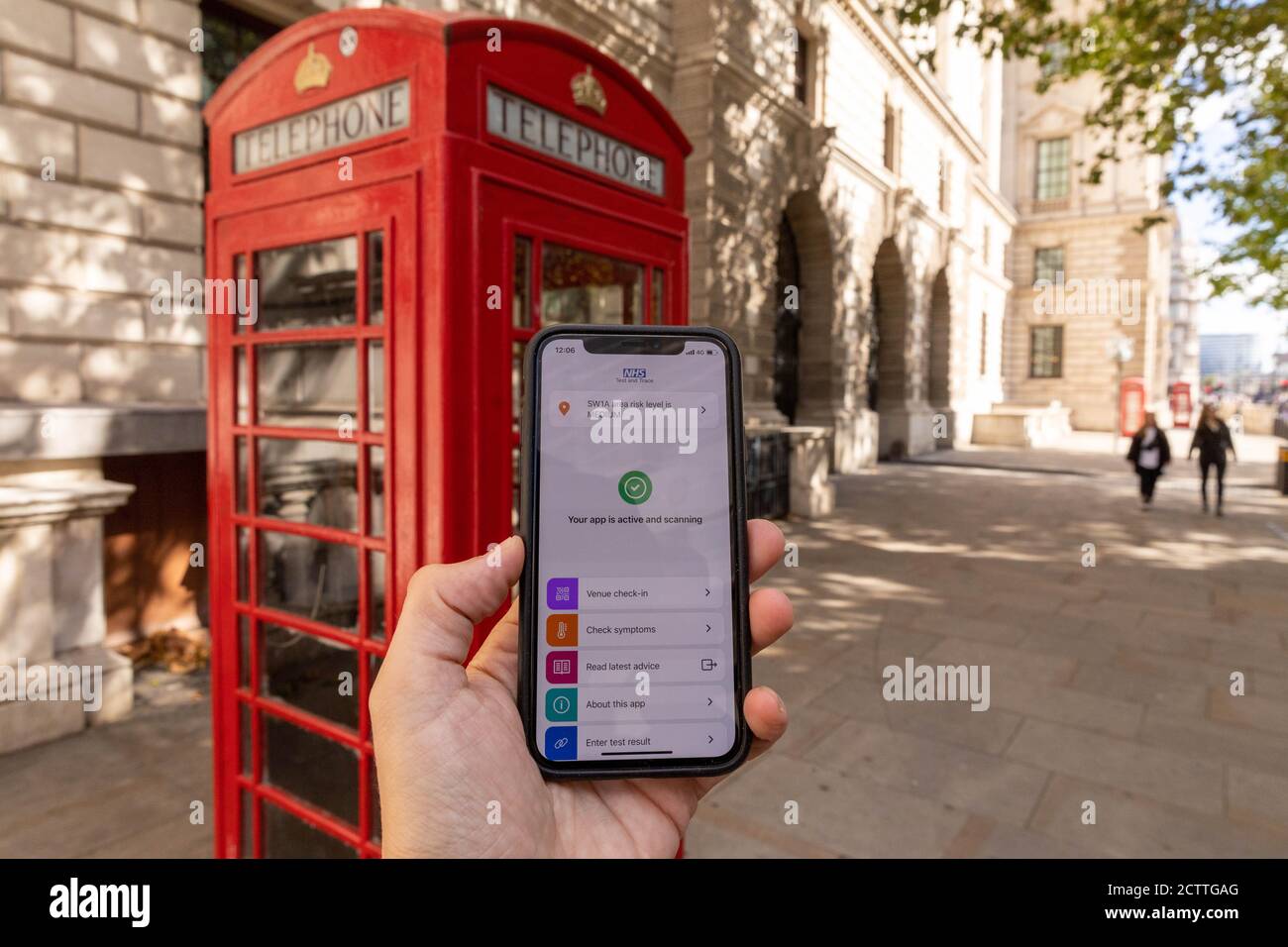 Londra, Regno Unito. 24 Settembre 2020. Foto scattata il 24 settembre 2020 mostra l'app NHS COVID-19 visualizzata su un telefono di fronte a una scatola telefonica rossa a Londra, Gran Bretagna. Giovedì, più di un milione di persone hanno scaricato l'app NHS COVID-19 per il tracciamento dei contatti, da lungo tempo attesa dal governo britannico, per l'Inghilterra e il Galles entro il suo primo giorno di lancio. L'app ufficiale NHS COVID-19 istruisce gli utenti a mettere in quarantena per 14 giorni se rileva che erano vicini a qualcuno che ha il virus. Credit: Tim Ireland/Xinhua/Alamy Live News Foto Stock