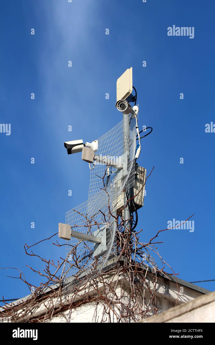 Torre di sorveglianza con due nuovi moderni colori bianco e nero Telecamere  TVCC a circuito chiuso e più trasmettitori e antenne Foto stock - Alamy