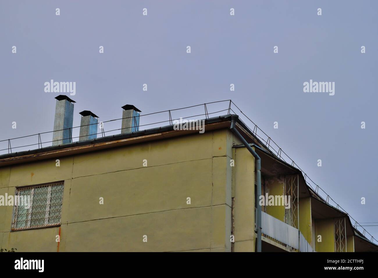 La cima di un vecchio edificio giallo sbiadito ad Angarsk, Russia Foto Stock
