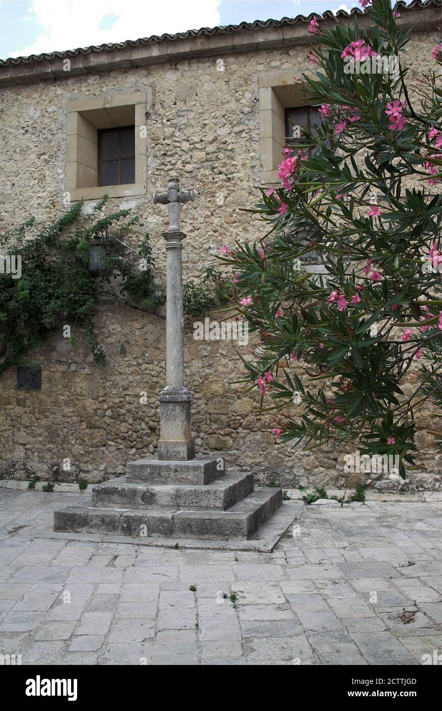 Pastrana, España, Hiszpania, Spagna, Spanien; una croce di pietra in un piccolo cortile vicino alla chiesa parrocchiale. Una cruz de piedra en el patio de la Colegiata Foto Stock