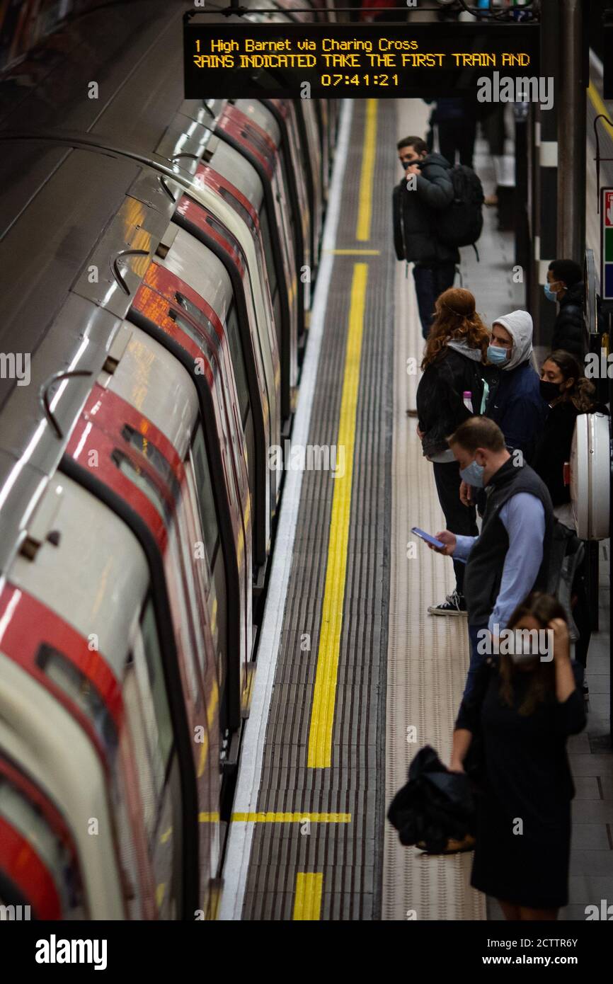 Pendolari su una piattaforma tubiera Northern line alle 06:41 nel centro di Londra, dopo che il primo ministro Boris Johnson ha annunciato una serie di nuove restrizioni per combattere l'aumento dei casi di coronavirus in Inghilterra. Foto Stock