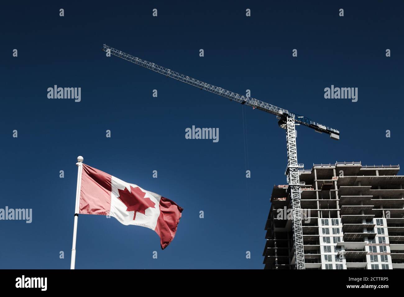 Bandiera canadese con costruzione di appartamenti in costruzione in background, economia canadese e mercato immobiliare. Foto Stock