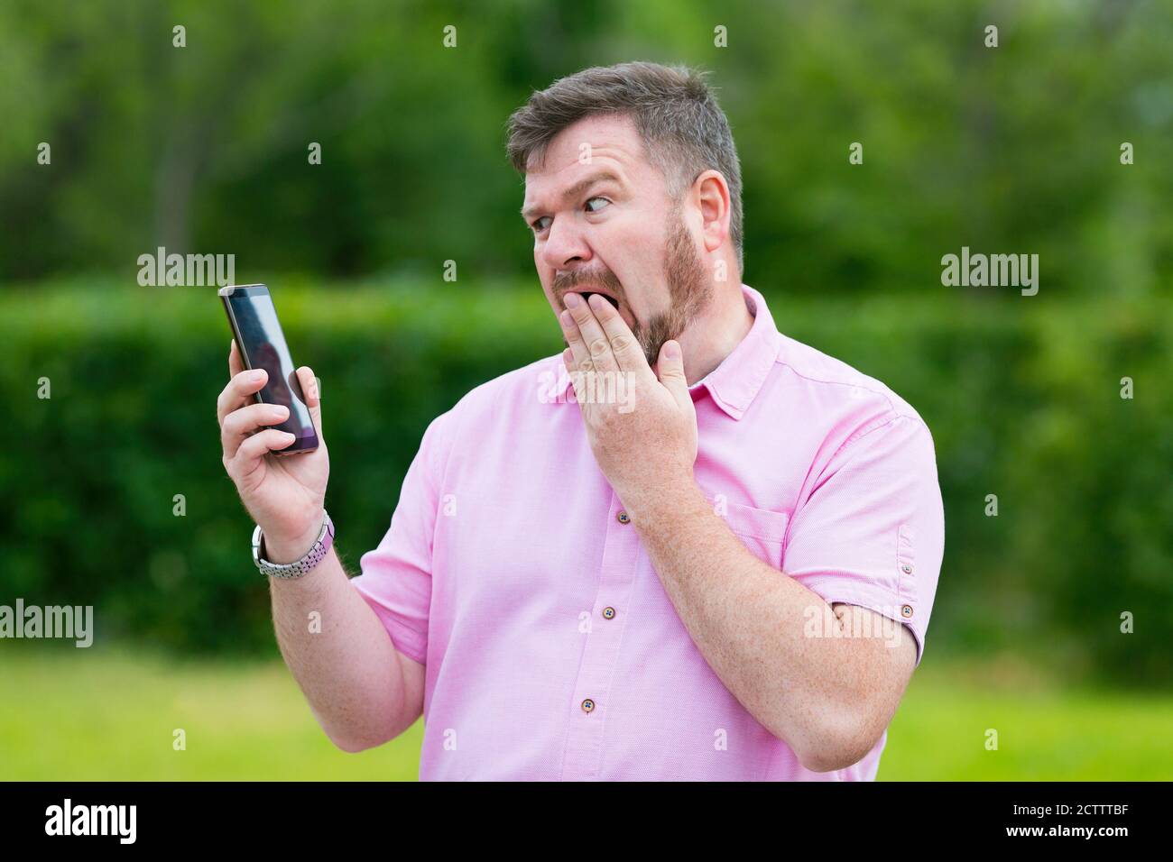 Conversazione emotiva di un uomo su uno smartphone mobile. Uomo adulto in incredulità e rabbia di parlare. Foto Stock