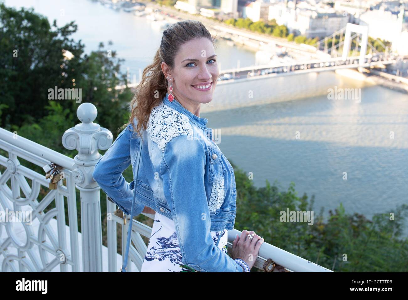 Felice giovane 30s caucasica donna sorride sopra la città Foto Stock