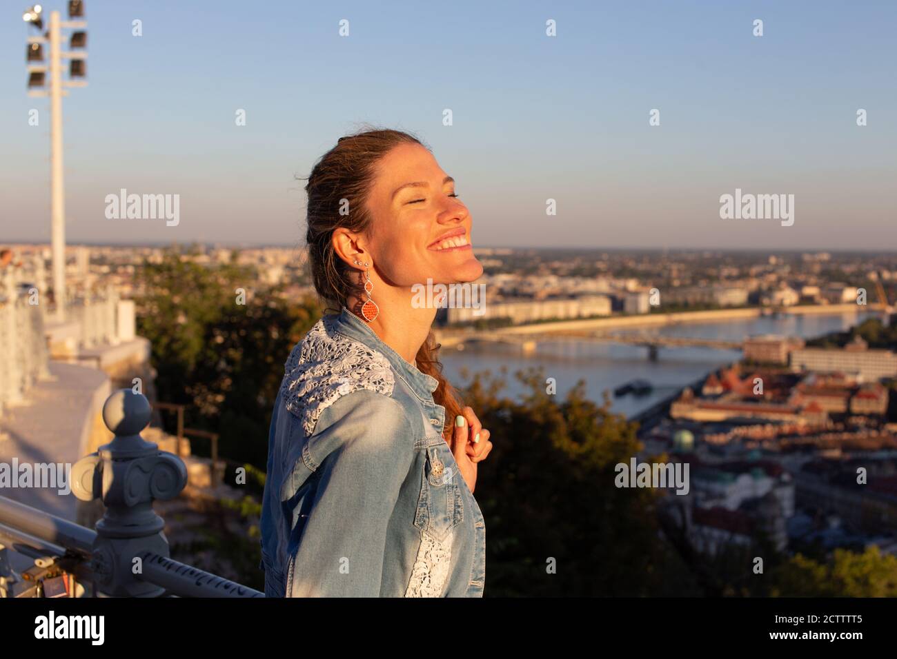 Felice giovane donna spensierata godendo il tramonto con gli occhi chiusi Foto Stock