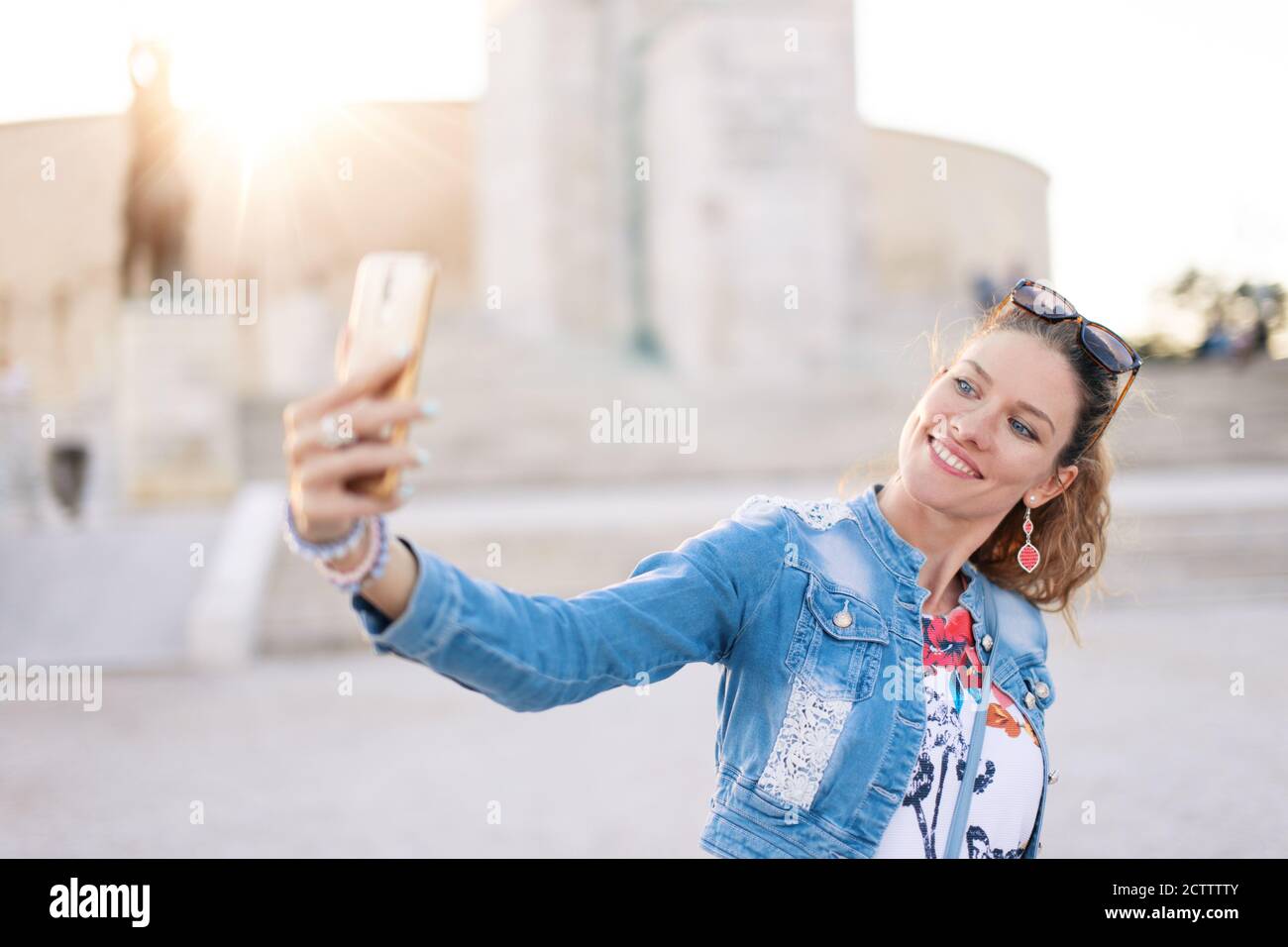 30s caucasica donna che prende selfie in luogo famoso in città Foto Stock