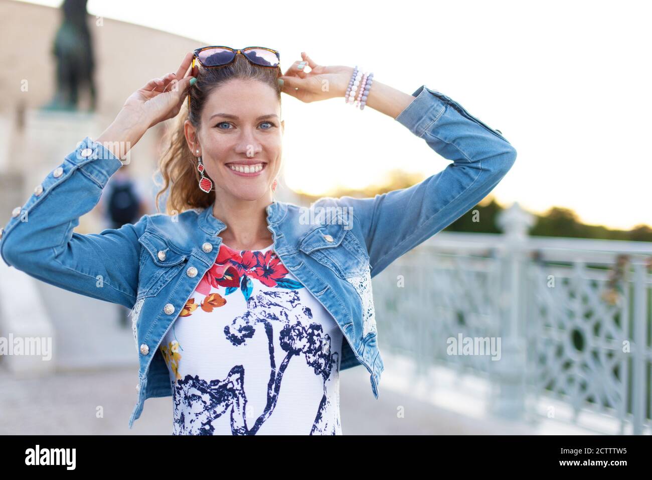 Felice giovane donna urbana con occhiali da sole in ritratto luce solare Foto Stock