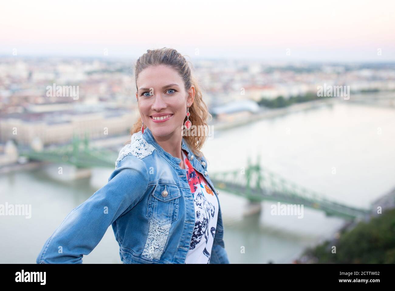 Giovane donna urbana che guarda in macchina fotografica nel panorama della città, Budapest, Ungheria Foto Stock