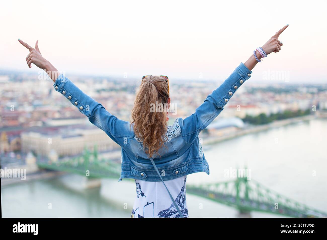 Le armi di giovane donna sollevate al Ponte della libertà, Budapest, Ungheria Foto Stock