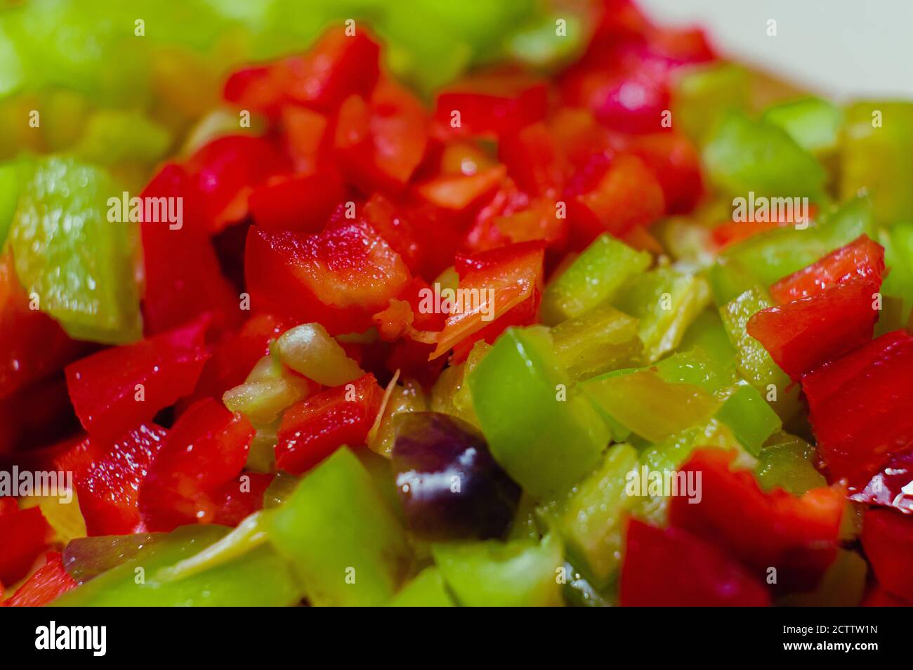 Primo piano di paprika rossa e verde tagliata in piccolo pezzi Foto Stock