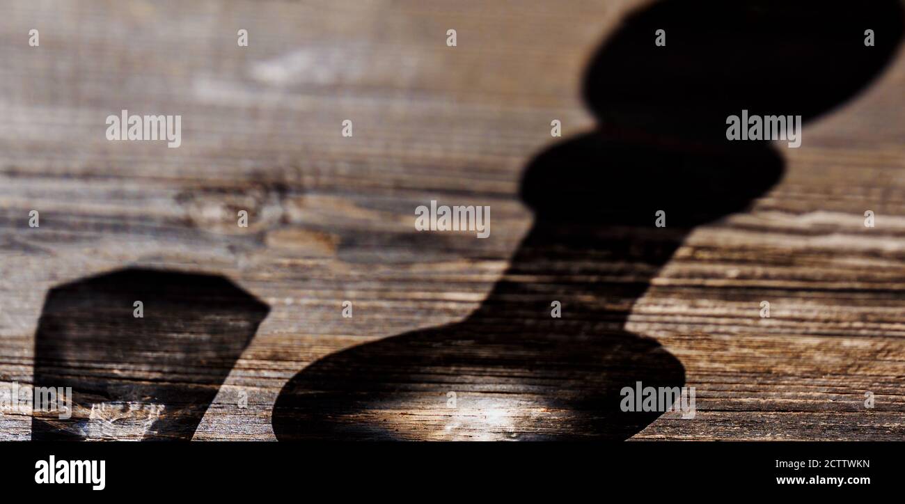 L'ombra di un decanter e di un vetro su una tavola di legno. Concetto di consumo di alcol Foto Stock