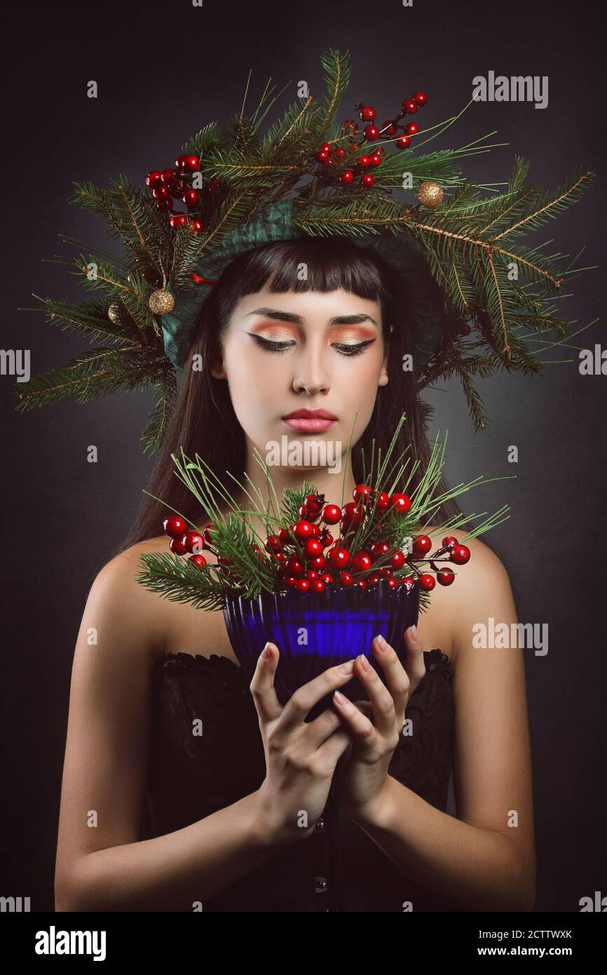 Bella donna con tazza piena di frutti di bosco .Inverno e fantasia Foto Stock