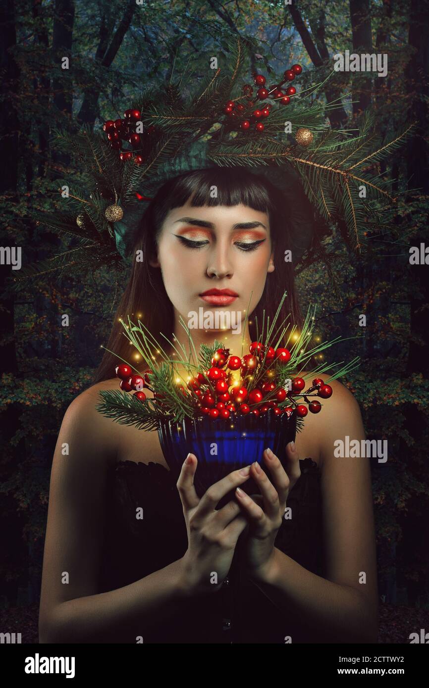 Bella donna con tazza magica della foresta. Inverno e. fantasia Foto Stock
