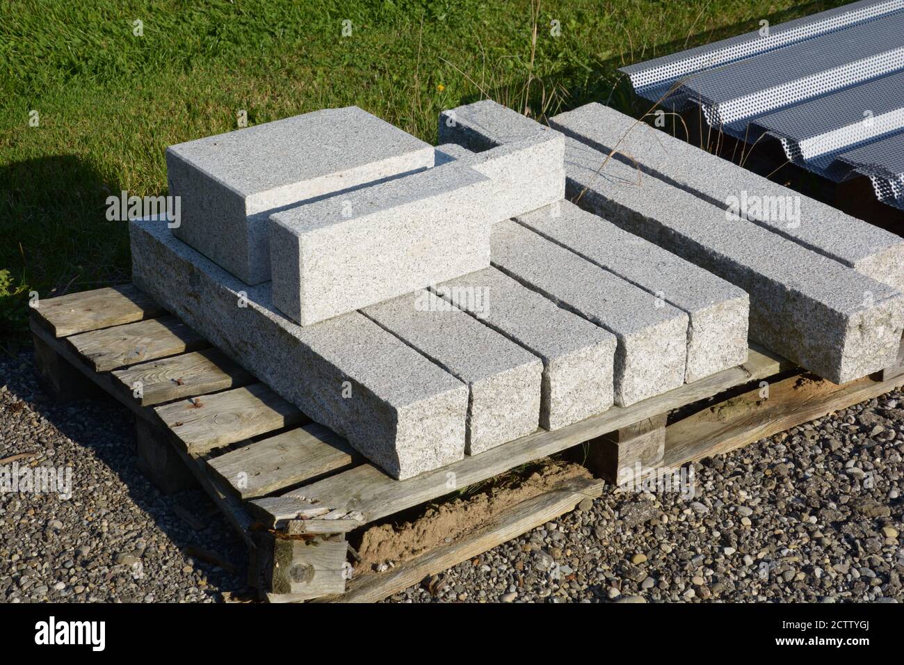 vecchio materiale di costruzione stradale di granito su pallet di legno Foto Stock