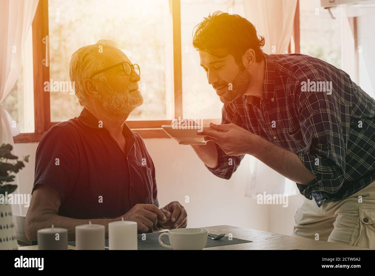 Felice anziano anziano uomo godere di cucina con la famiglia al cucina soggiorno home attività di svago e la gente stile di vita Foto Stock