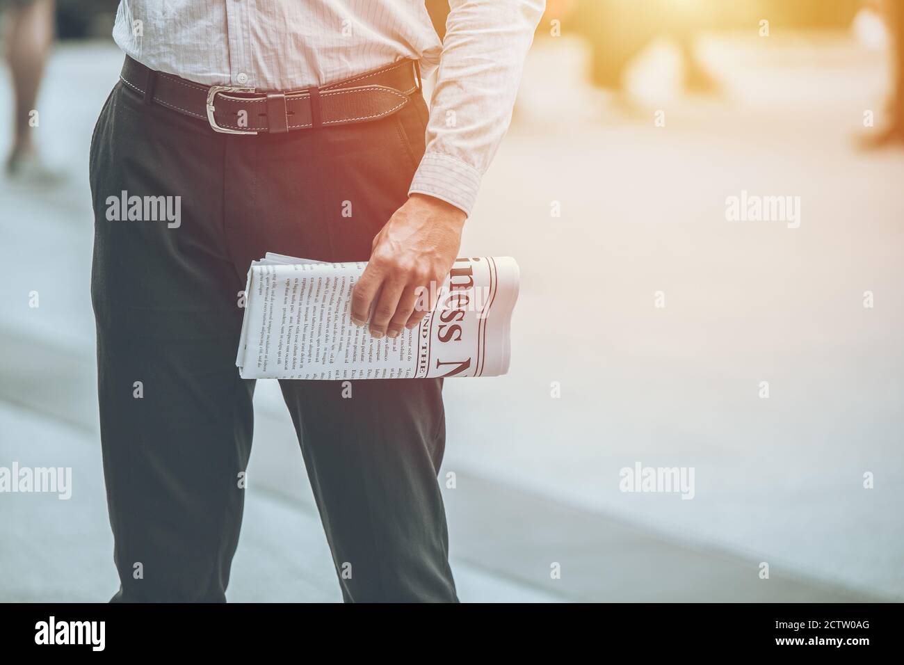 Uomo d'affari mano che tiene mockup fake business news paper per la lettura ogni mattina giorno con spazio per il testo. Foto Stock