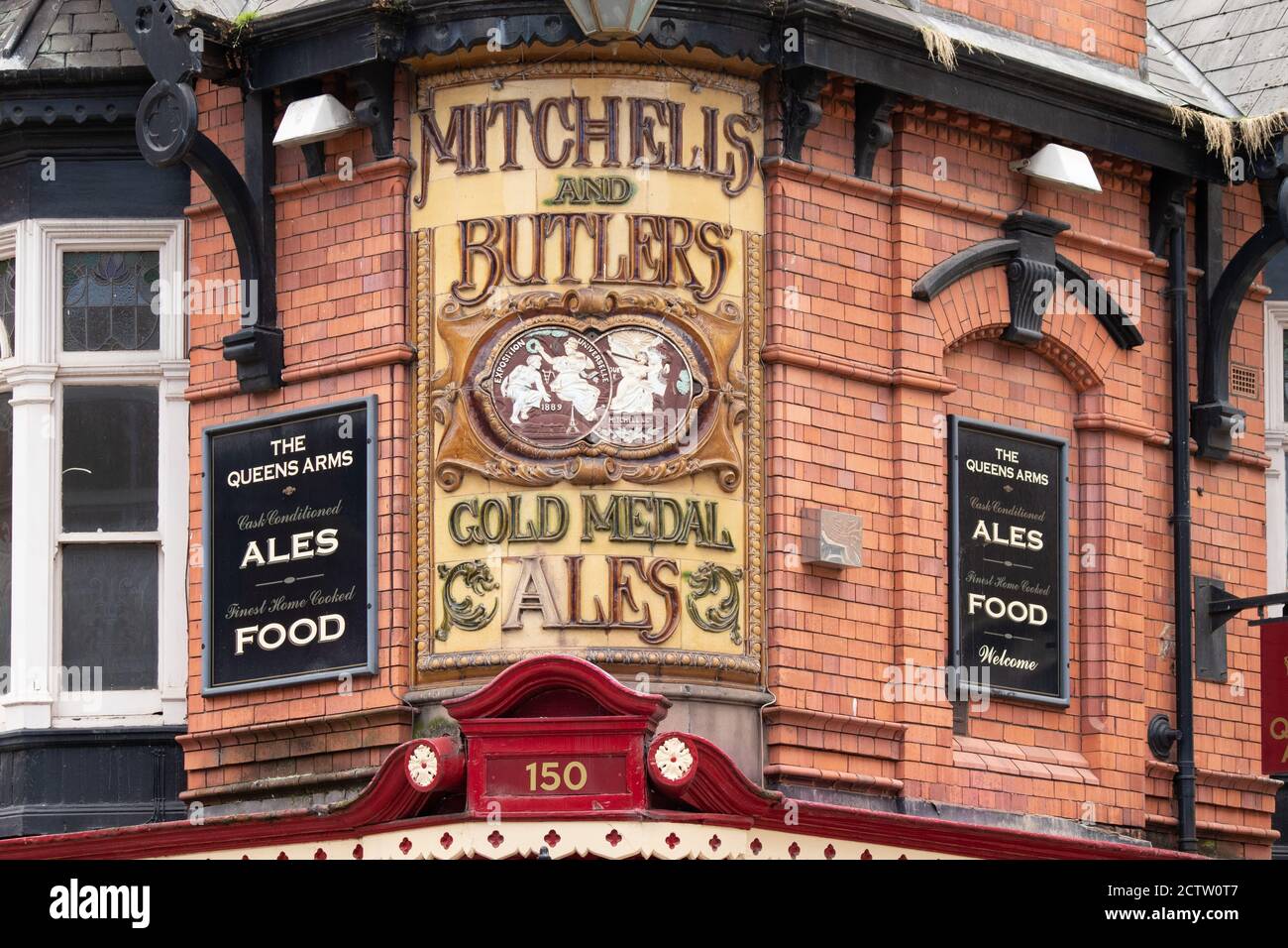La segnaletica ornata all'angolo della Queens Arms Public House a Newhall Street Birmingham. Un tempo il pub era di proprietà di Mitchells e Butlers, un importante produttore di birra nelle Midlands. Foto Stock