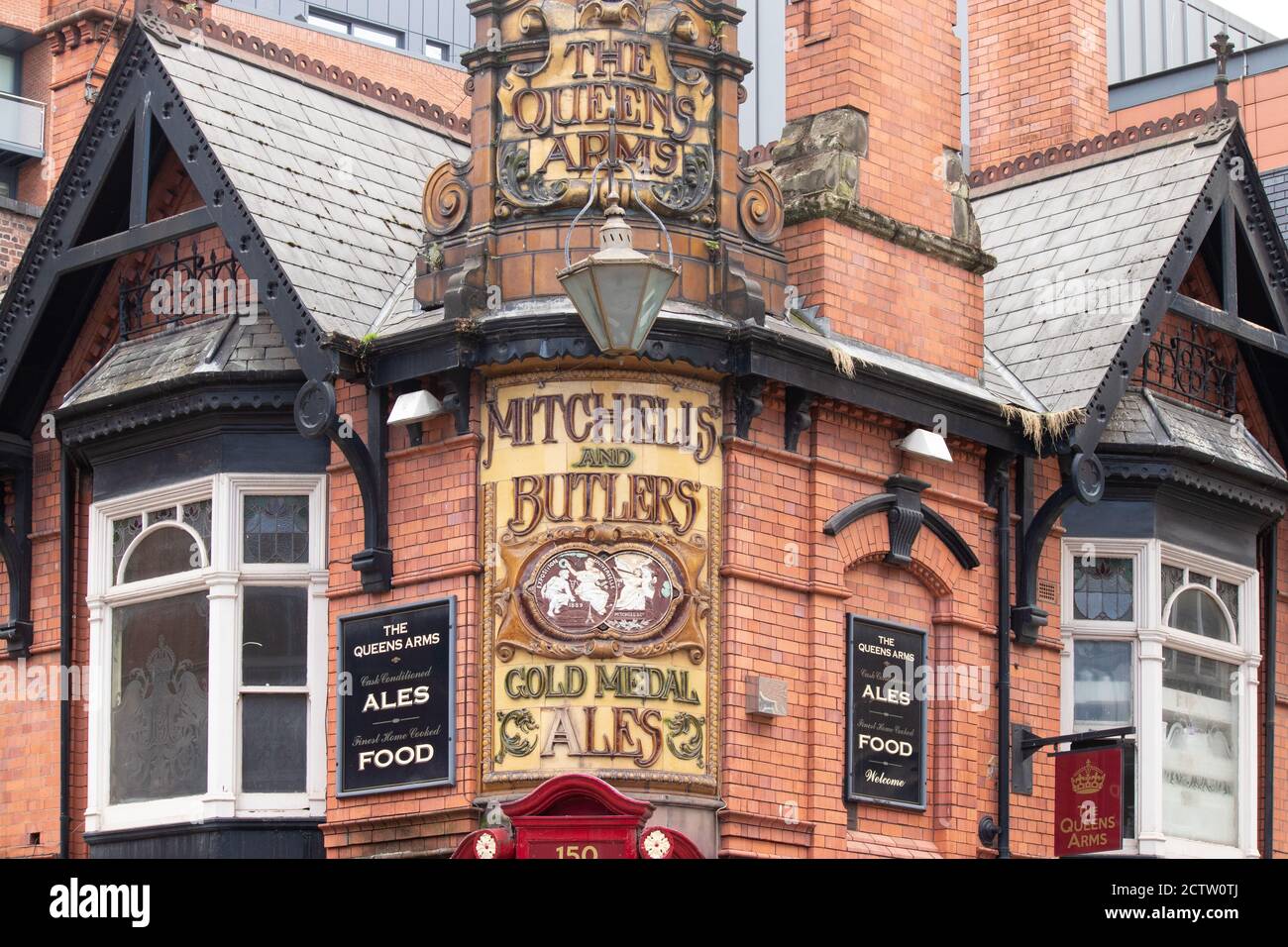 La segnaletica ornata all'angolo della Queens Arms Public House a Newhall Street Birmingham. Un tempo il pub era di proprietà di Mitchells e Butlers, un importante produttore di birra nelle Midlands. Foto Stock