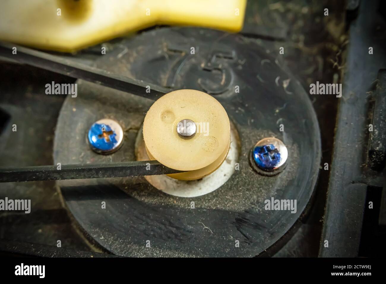 un motorino elettrico con una puleggia in plastica ruota su una cinghia di gomma. Meccanismo con ingranaggi in plastica. Foto Stock
