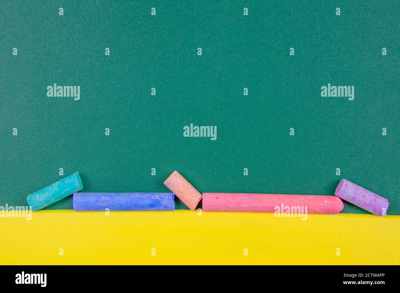 Pulire la lavagna verde con pastelli colorati e spazio per la copia. Istruzione, formazione scolastica Foto Stock
