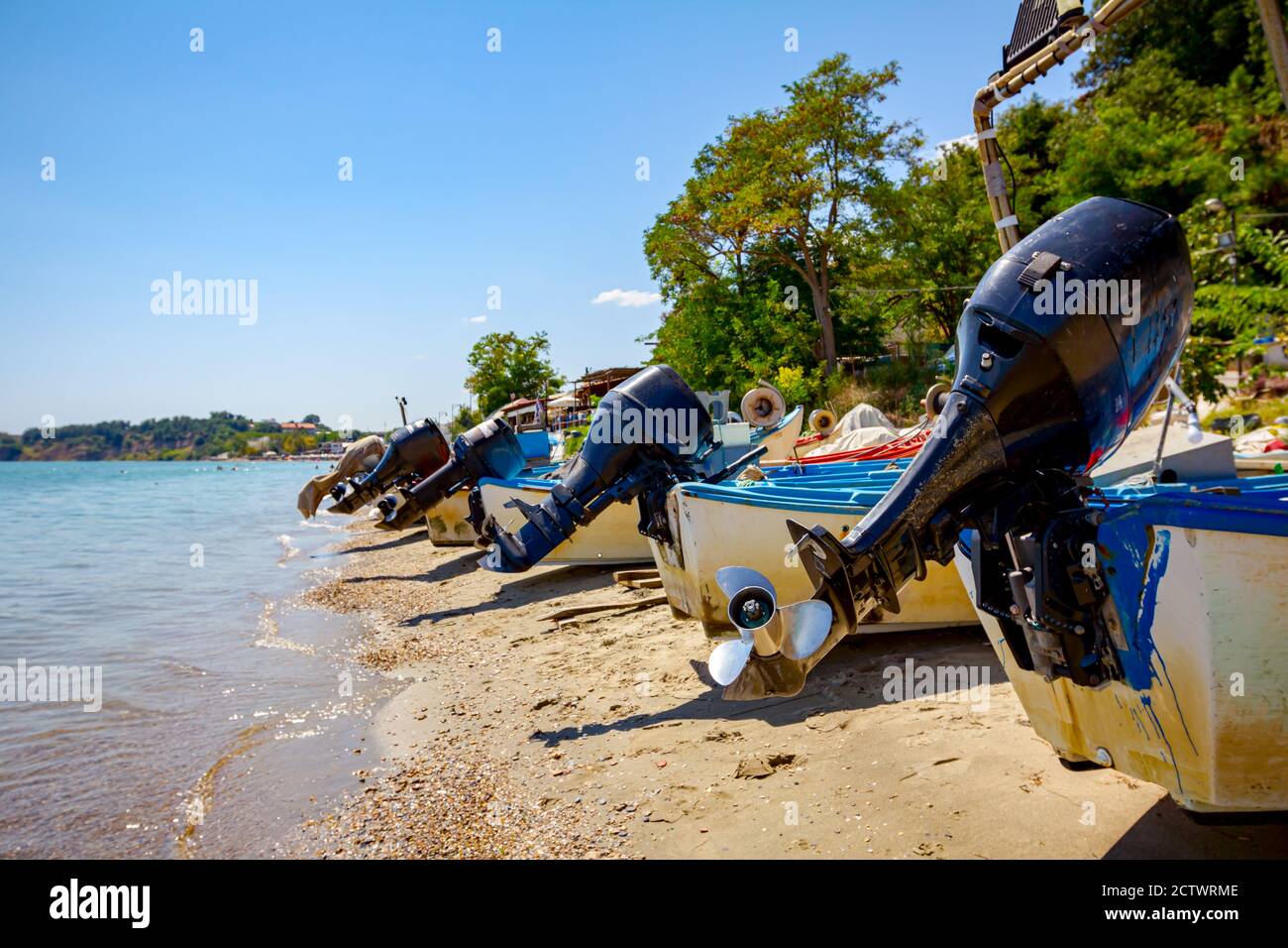 Vista su eliche di motoscafi sulla spiaggia di sabbia, le onde schiumose stanno spruzzando la riva Foto Stock