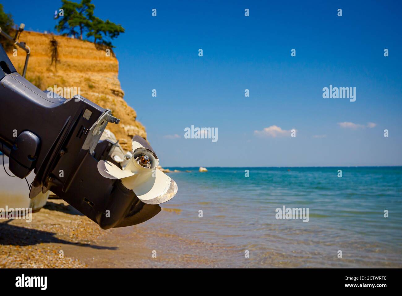 Vista sul propulsore del motoscafo sulla spiaggia di sabbia, le onde schiumose stanno spruzzando la riva Foto Stock