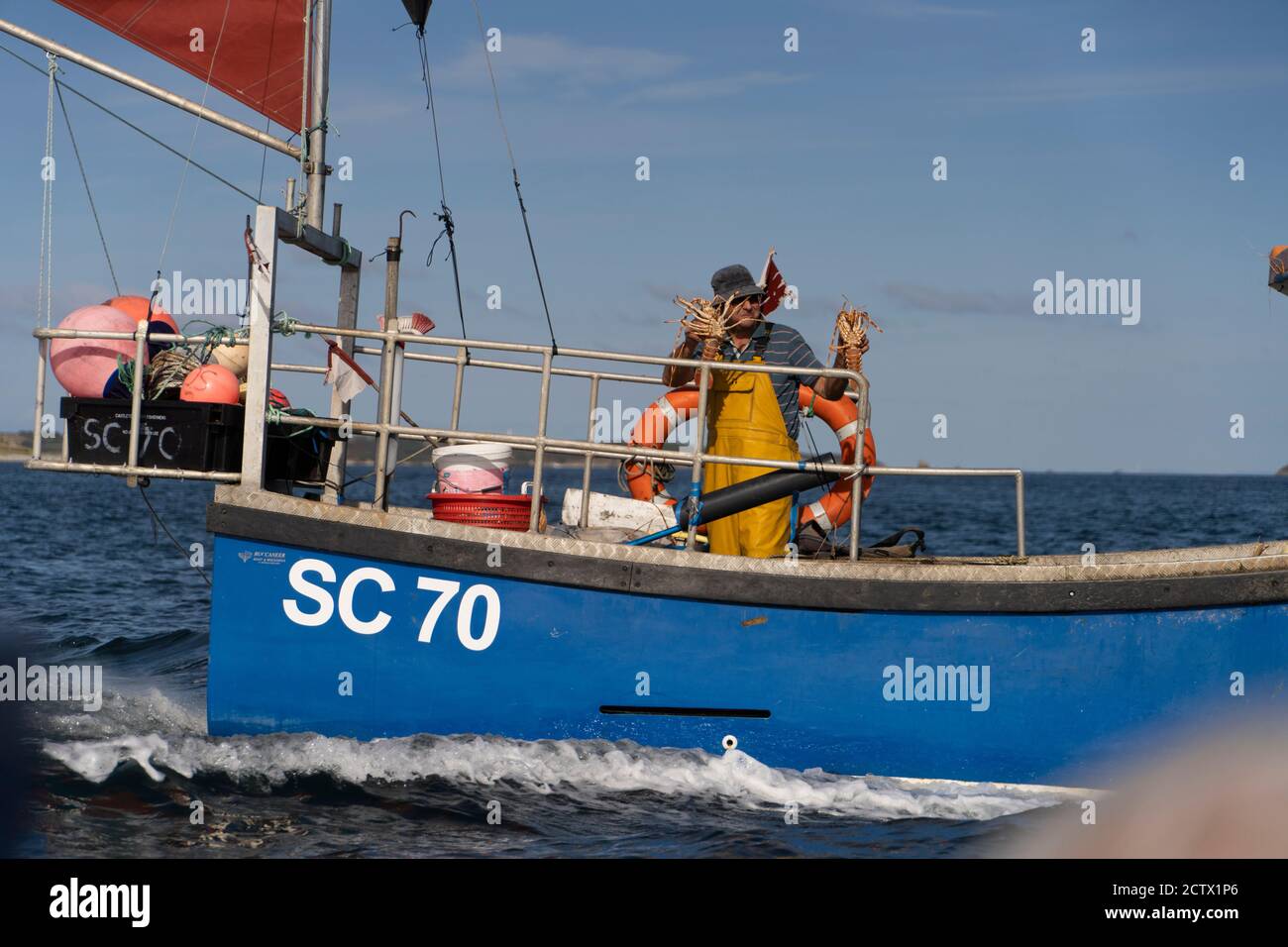 Un pescatore che tiene due aragoste, Isles of Scilly. Foto Stock