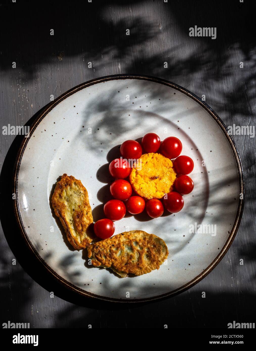 frittelle di zucchine e una torta di butternut con pomodoro piccolo sotto forma di fiore. Foto Stock