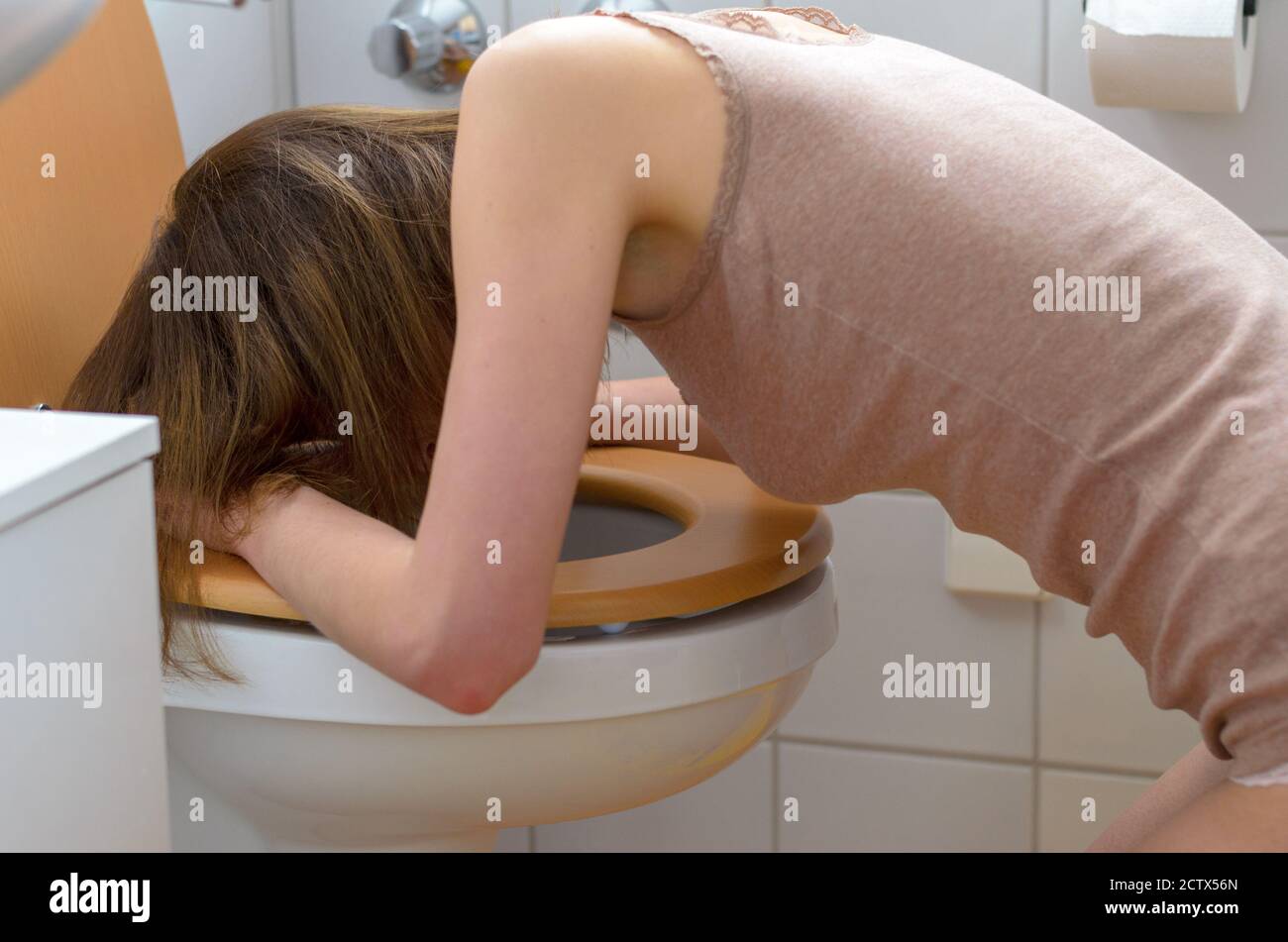 Vista laterale su malati giovane donna indossa camicia senza maniche in piega su open water al bagno interno Foto Stock