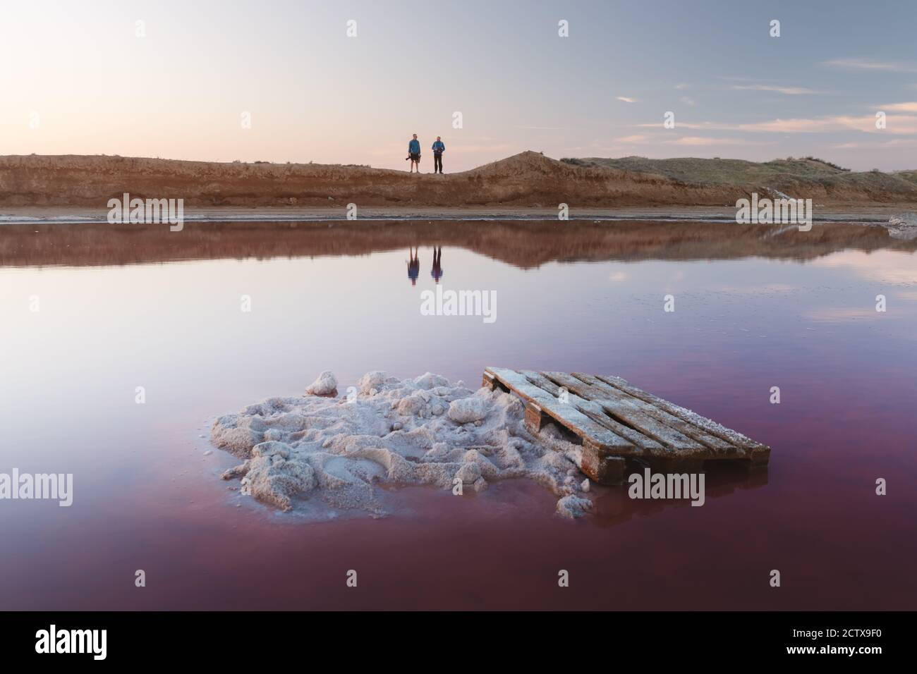 Cristalli di sale in acqua rosa lago di sale in Ucraina, Europa. Due fotografi sullo sfondo. Fotografia di paesaggio Foto Stock