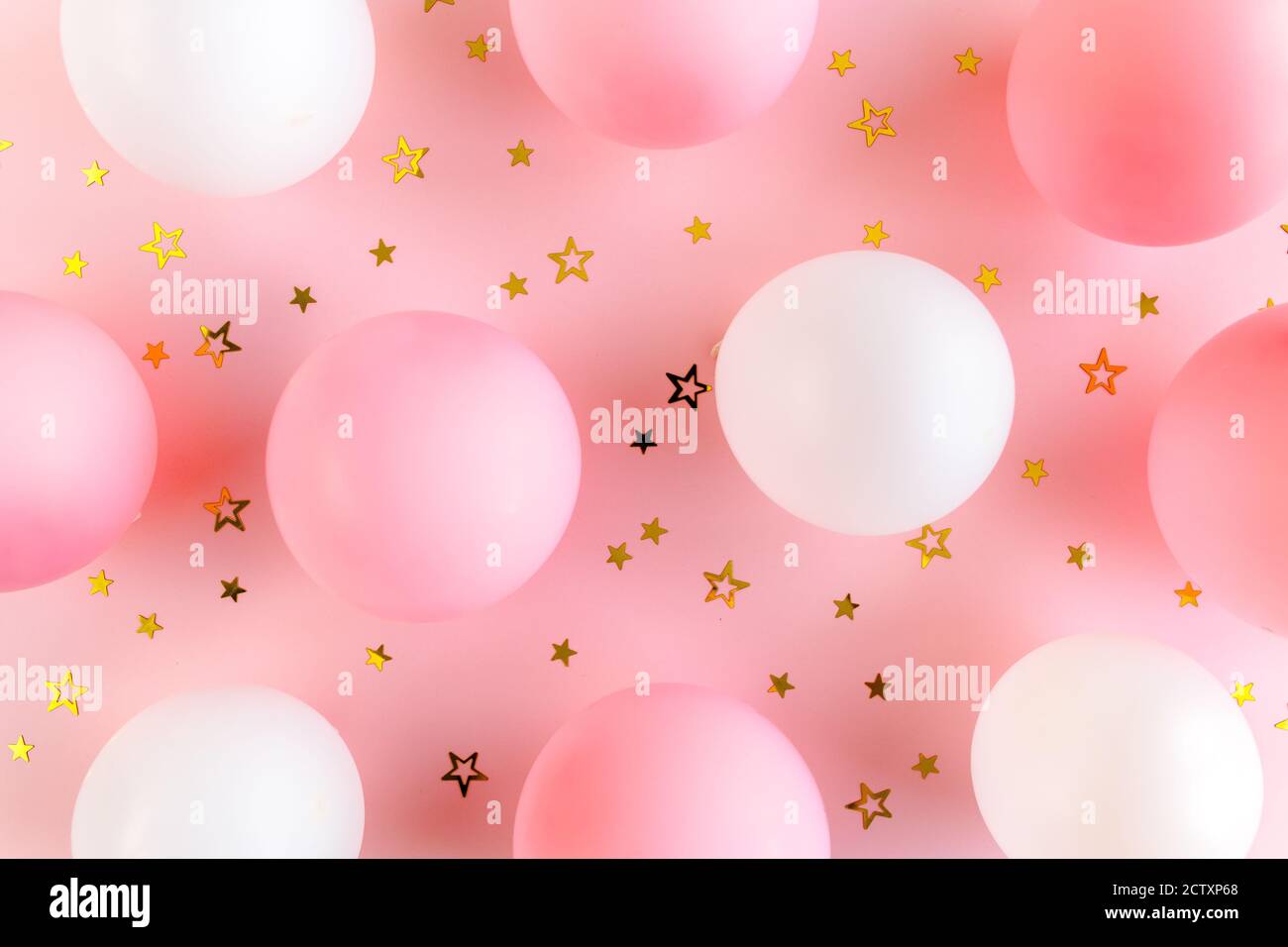 Palloncini e confetti su sfondo rosa. Giorno di San Valentino, compleanno, concetto di vacanza. Disposizione piatta, vista dall'alto Foto Stock
