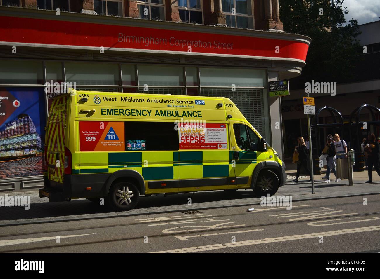 I paramedici del servizio di ambulanza delle Midlands occidentali assistono ad un incidente nel centro della città di Birmingham, Regno Unito, sulla strada della società fuori del negozio di Vodafone Foto Stock