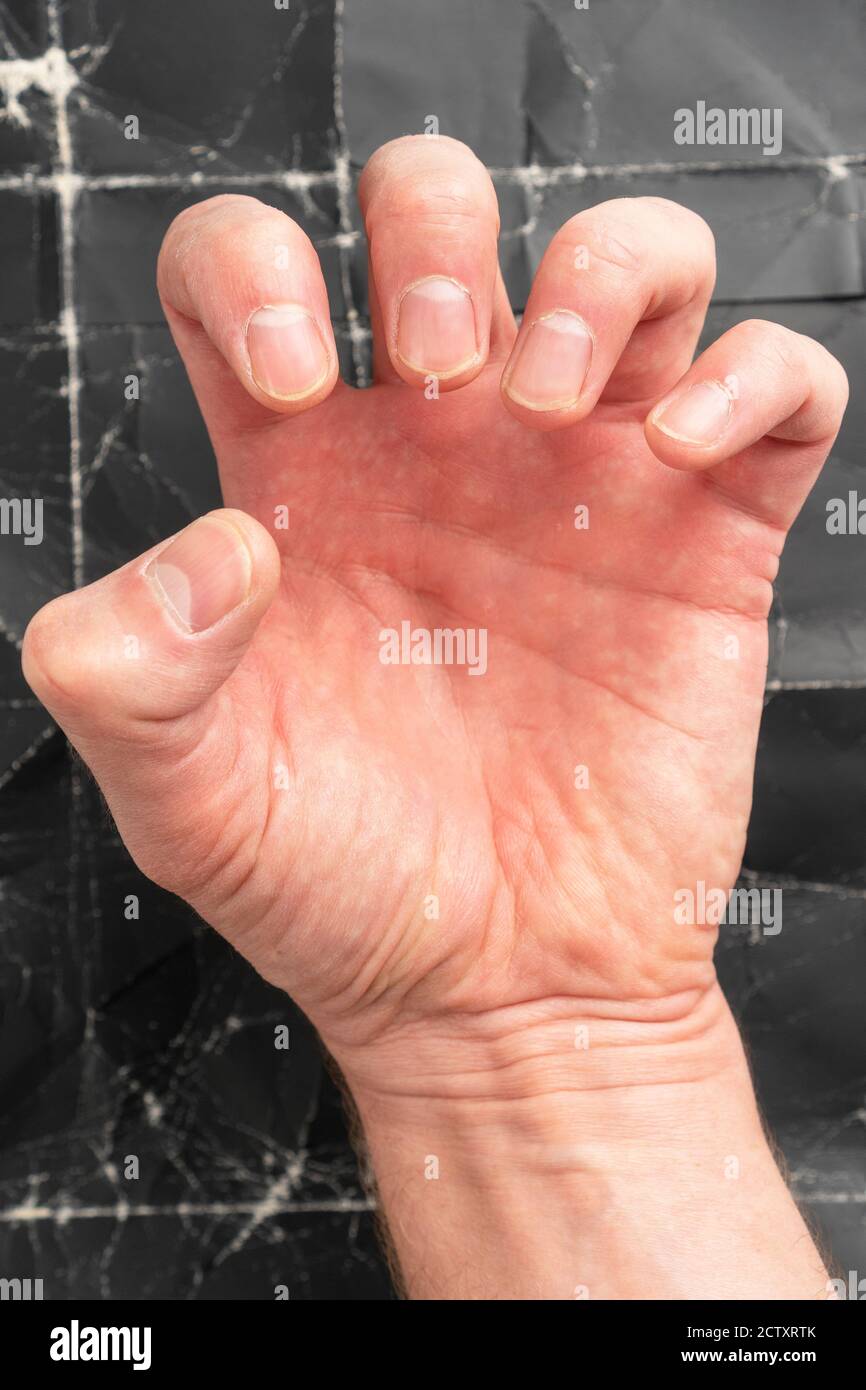 Uomo che clenching pugno su sfondo nero grunge primo piano Foto Stock