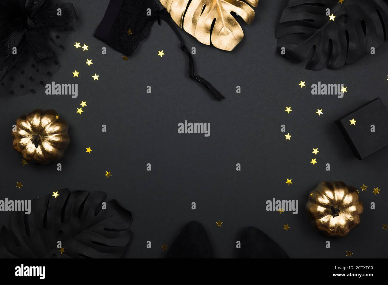 Halloween party collection accessori outfit femminile su sfondo nero: cappello con velo, cintura garter, regali. Zucche nere e dorate, piatto, top Foto Stock