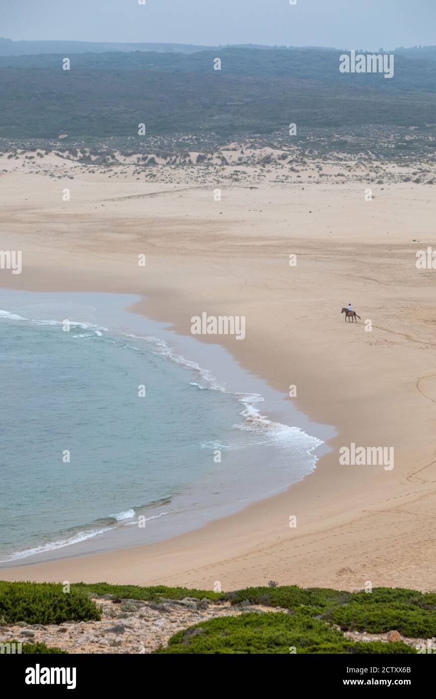 Uomo a cavallo a praia da Bordeira, vicino al villaggio di Carrapateira, em Alzejur Foto Stock
