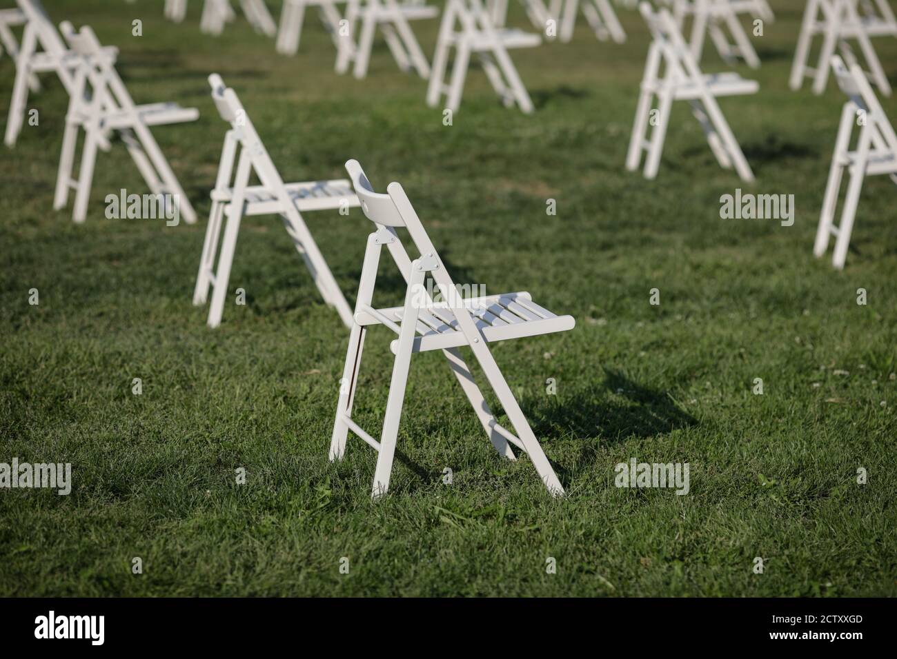 Sedie l'una l'altra per mantenere la distanza sociale Durante l'epidemia di Covid-19 in un evento all'aperto sul erba Foto Stock