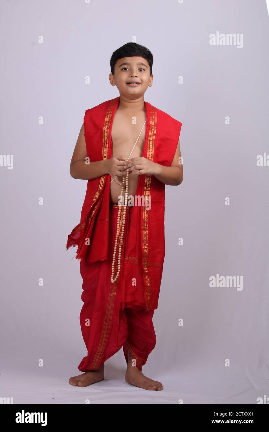 Ragazzo carino in indiano etnico indossare canti nome di Dio / jaap. Utilizzando una stringa di rosario di perle di preghiera o japamala. Foto Stock