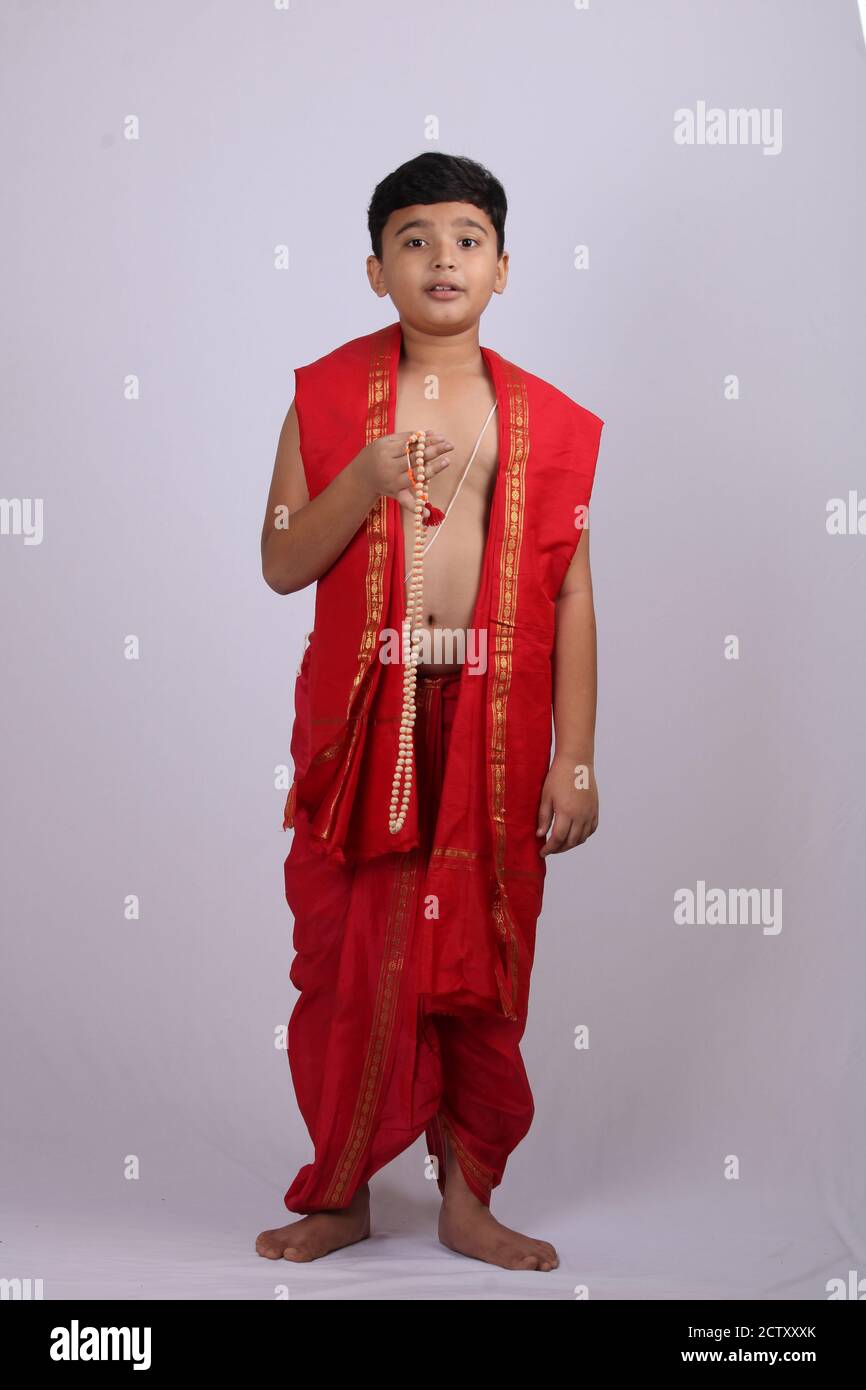 Ragazzo carino in indiano etnico indossare canti nome di Dio / jaap. Utilizzando una stringa di rosario di perle di preghiera o japamala. Foto Stock