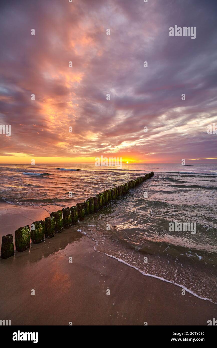 Tramonto panoramico sul Mar Baltico con una vecchia pausa in legno sulla spiaggia. Foto Stock Tramonto panoramico sul Mar Baltico con una vecchia pausa in legno sulla spiaggia. Foto Stock