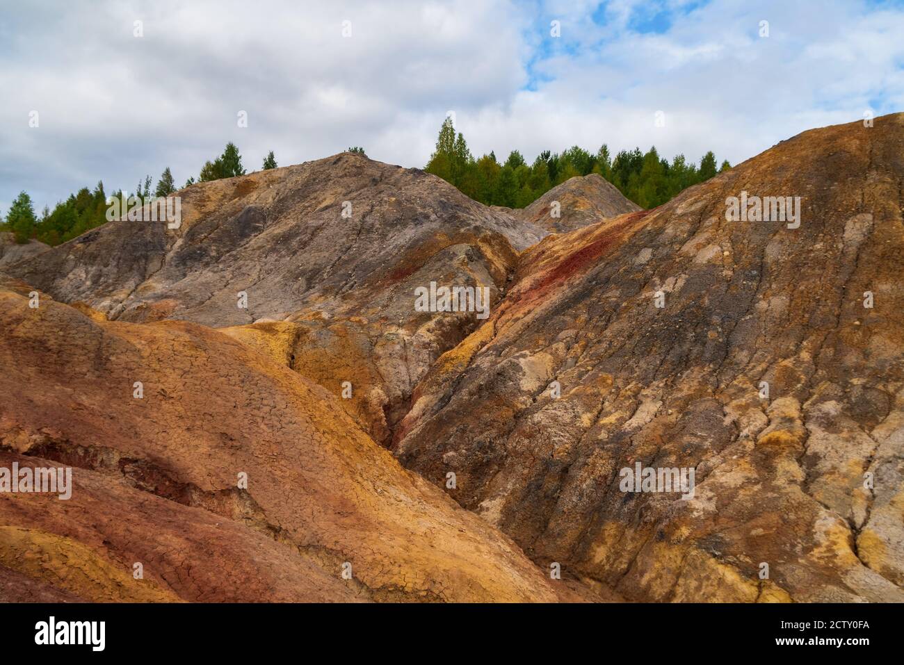 Insolitamente bellissimo paesaggio autunnale di laghi rossi, pendii colorati e foresta. Ural Marte. Increspature di acqua rossa scura sulla superficie di un lago senza vita Foto Stock